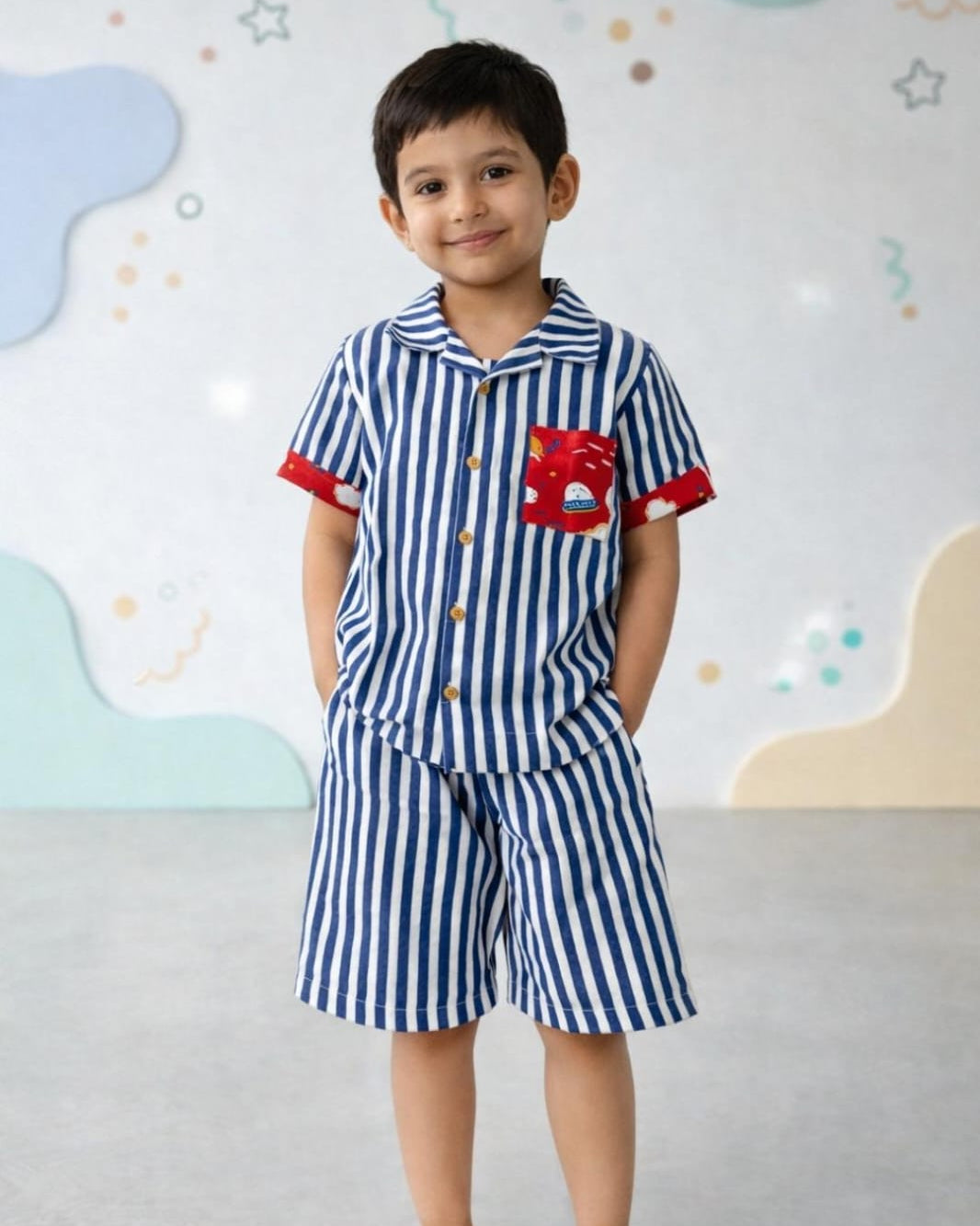 Kids blue and white striped outfit with a red pocket on a colorful cloud-patterned background in cotton fabric and is and block printed 